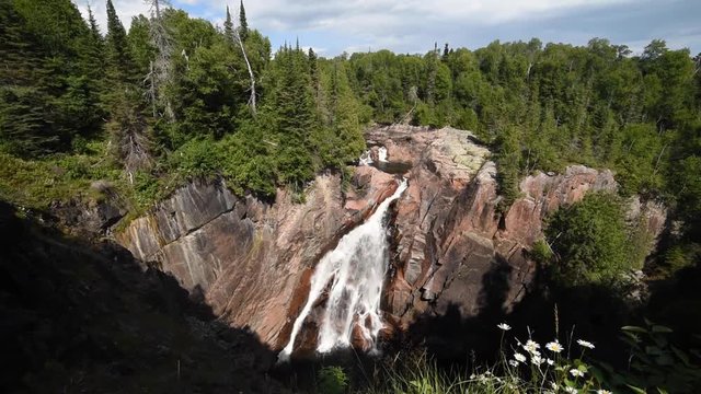large waterfall cascading over pick quartz rock