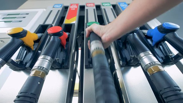 Male hand is putting a green gas pistol back into its pump