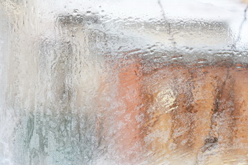 frosty pattern on glass winter window, look through glass 