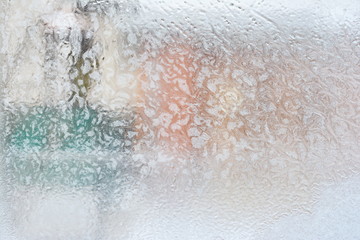 frosty pattern on glass winter window, look through glass 