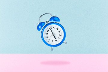 blue alarm clock on a pink azure background