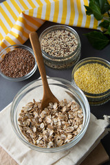 Uncooked oatmeals with various uncooked cereals on gray background, top view, close up. Healthy nutrition food