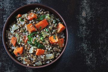 Buckwheat porridge with vegetables and herbs in a bowl. Flat lay. Healthy vegan food concept. Buckwheat diet