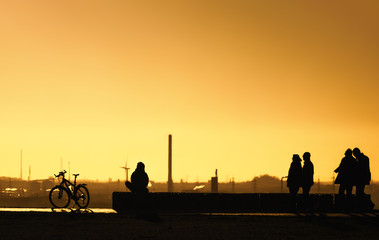 Fototapeta na wymiar Menschen gehen spazieren bei Sonnenuntergang