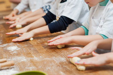 Obraz na płótnie Canvas Young children make dough products. Hands closeup