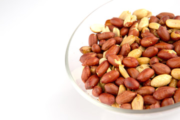 Roasted peanuts in a glass plate isolated on white background