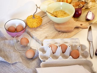 Fototapeta na wymiar Eggs, pumpkins, sea salt on a light table, top view, home cooking ingredients, shades of yellow