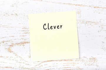 Yellow sticky note with handwritten word clever