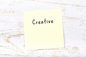 Yellow sticky note with handwritten word creative