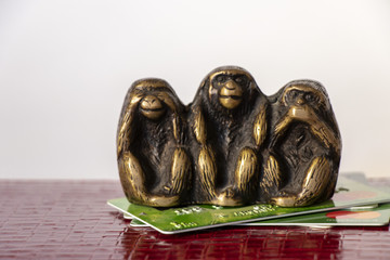 credit cards on them sit three monkeys a symbol of the local Japanese religion on a white background - business finance © Виктория Котлярчук