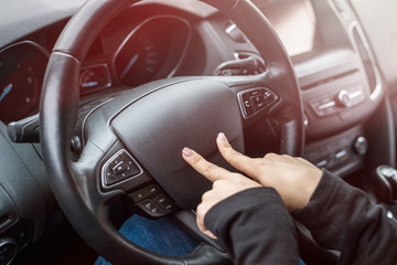Female hands pointing with fingers on steering wheel