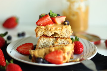 French toast with strawberries, blueberries and peanut butter.
