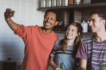 Happy friends taking selfie indoors
