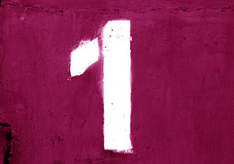 Number 1 in stencil on metal wall in pink color.