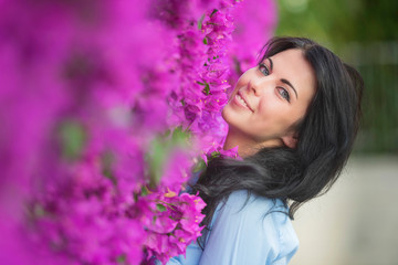 Naklejka premium Outdoor fashion photo of beautiful young woman surrounded by flowers. Spring blossom