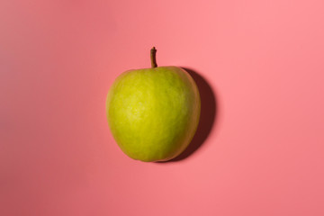 Sliced green delicious apple isolated on pink background with contrast shadows