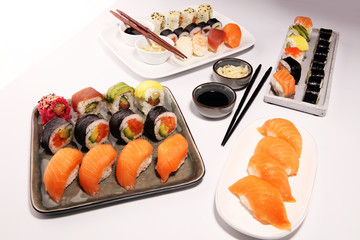 close up of sashimi sushi set with chopsticks and soy - sushi roll with salmon and sushi roll with smoked eel