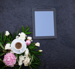 Creative flat lay with digital tablet mockup, bouquet of flowers and cup of coffee. Floral pattern on white top view, copy space.