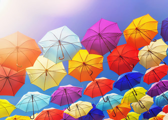 Fototapeta na wymiar Colorful umbrellas on the sky background, toned.