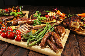 Assorted delicious grilled meat with vegetable on rustic table