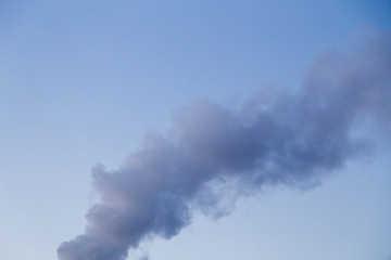 Smoke coming from a heat plant chimney on a cold winter evening