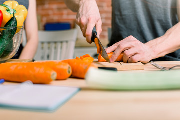 Healthy lifestyle, healthy food. A young man prepares a salad from fresh vegetables and fruits.