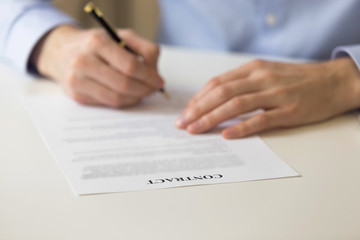 Man signing contract close up hands and document