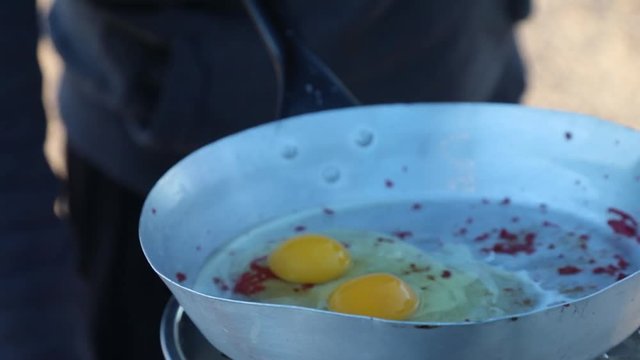 Preparing Breakfast With Eggs And Bacon On A Camping Gas Stove While In Bush Of Namibia Wilderness