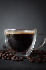 Coffee cup with fresh brewed coffee and brown roasted coffee beans