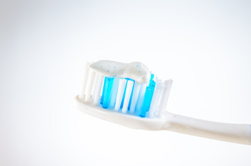 toothbrush with toothpaste on a wigh background, close up