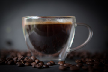Coffee cup with fresh brewed coffee and brown roasted coffee beans