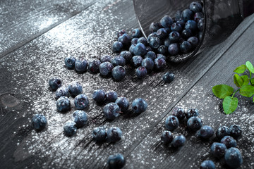 Organic fresh blueberries in glass Cup on black wooden background. Healthy home nutrition