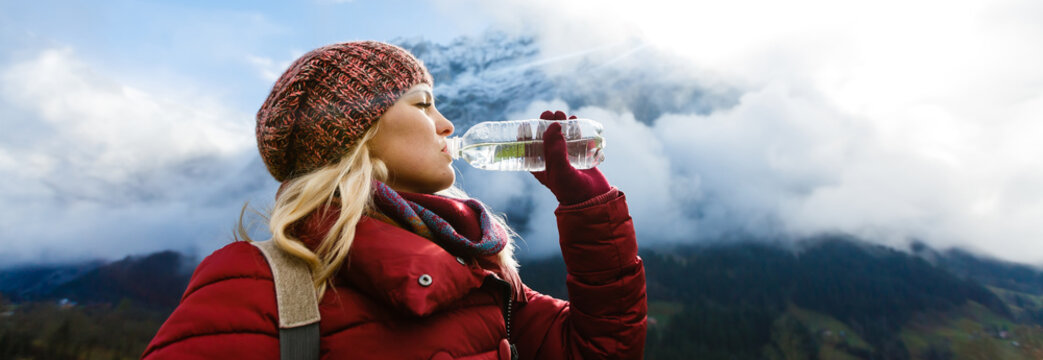 A woman tourist excited while looking at a high mountain against a blue sky in the Alps, Switzerland