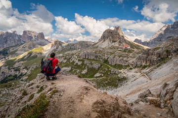 Fototapeta premium Man traveler hiking alone in breathtaking landscape of Dolomites mountains in summer in Italy.