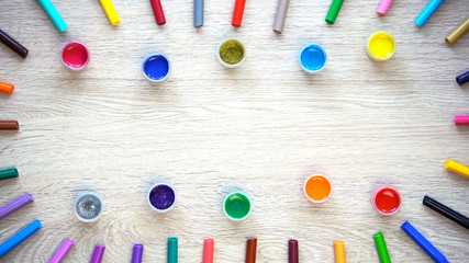 Colored paints and felt-tip pens lying on table, design and graphics courses