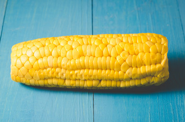 ear of boiled appetizing corn on a blue background/vegetarian concept, ear of boiled appetizing...