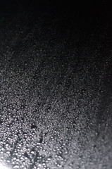 Regentropfen auf grauem Metall