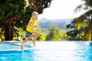 Child in swimming pool. Summer vacation with kids.