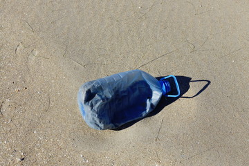 Big plastic bottle at the sand 