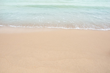 Fototapeta na wymiar Soft wave of sea on empty sandy beach Background with copy space