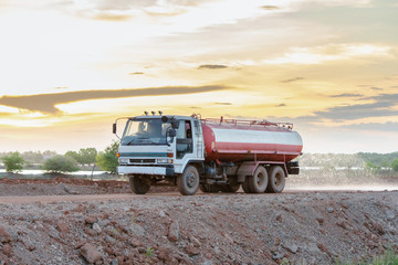 Water truck sprays water for a new road construction site.