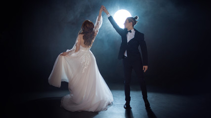 Couple dancing, the bride and groom under the moon. Hugs together. Man and woman, wedding dress.