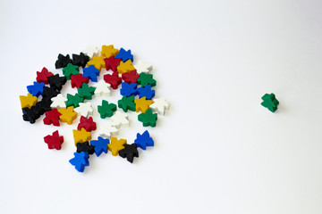 Groups of colorful meeples isolated on white background. Blue, red, black, green and yellow. Small figures of man. Board games concept. Business strategy. Components of card games. White crow in crowd