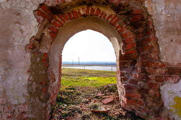arched entrance to the wall on the ruins of an old medieval red brick building
