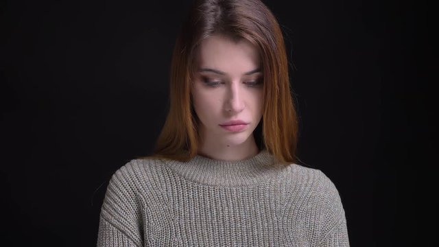 Closeup portrait of young beautiful caucasian female being upsed and sad while looking straight at camera