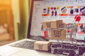 Shopping online concept - Parcel or Paper cartons with a shopping cart logo in a trolley on a...