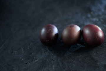 Dark purple eggs on a rough cement background