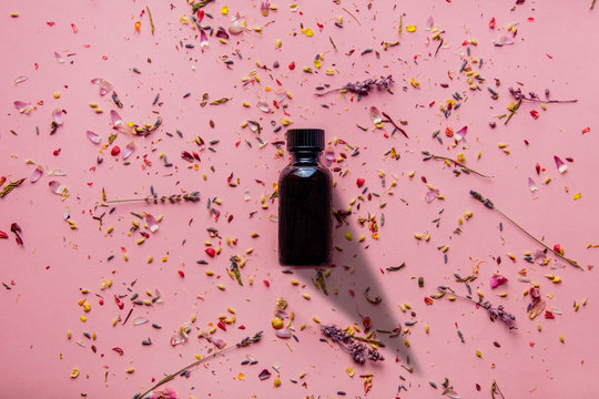 black glass bottle with pealing and lavender flower petals