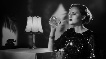Beautiful blonde woman enjoying a glass of whiskey in a glamorous hotel bar