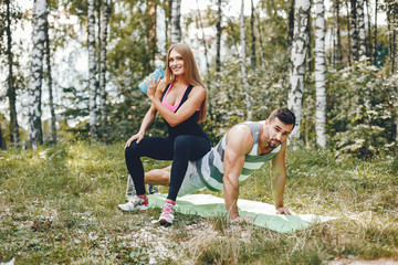 Handsome man in a park. Sportsman in a sportswear. Couple training